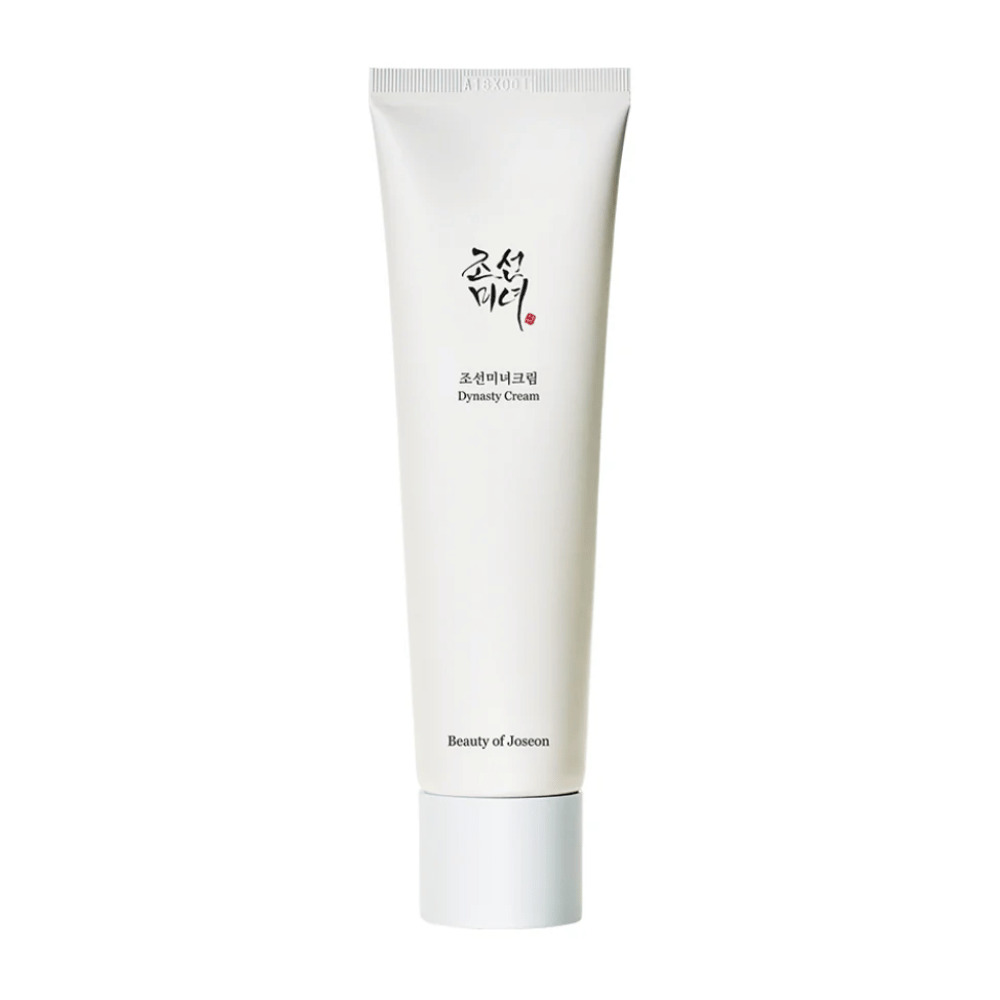 Bildet viser en tube av "Beauty of Joseon Dynasty Cream". Den slanke, hvite tuben har minimalistiske designelementer, inkludert elegant svart og rød tekst. Dette hudpleieproduktet lover å nære og vitalisere huden, noe som gjenspeiler de historiske skjønnhetshemmelighetene fra Joseon-dynastiet.