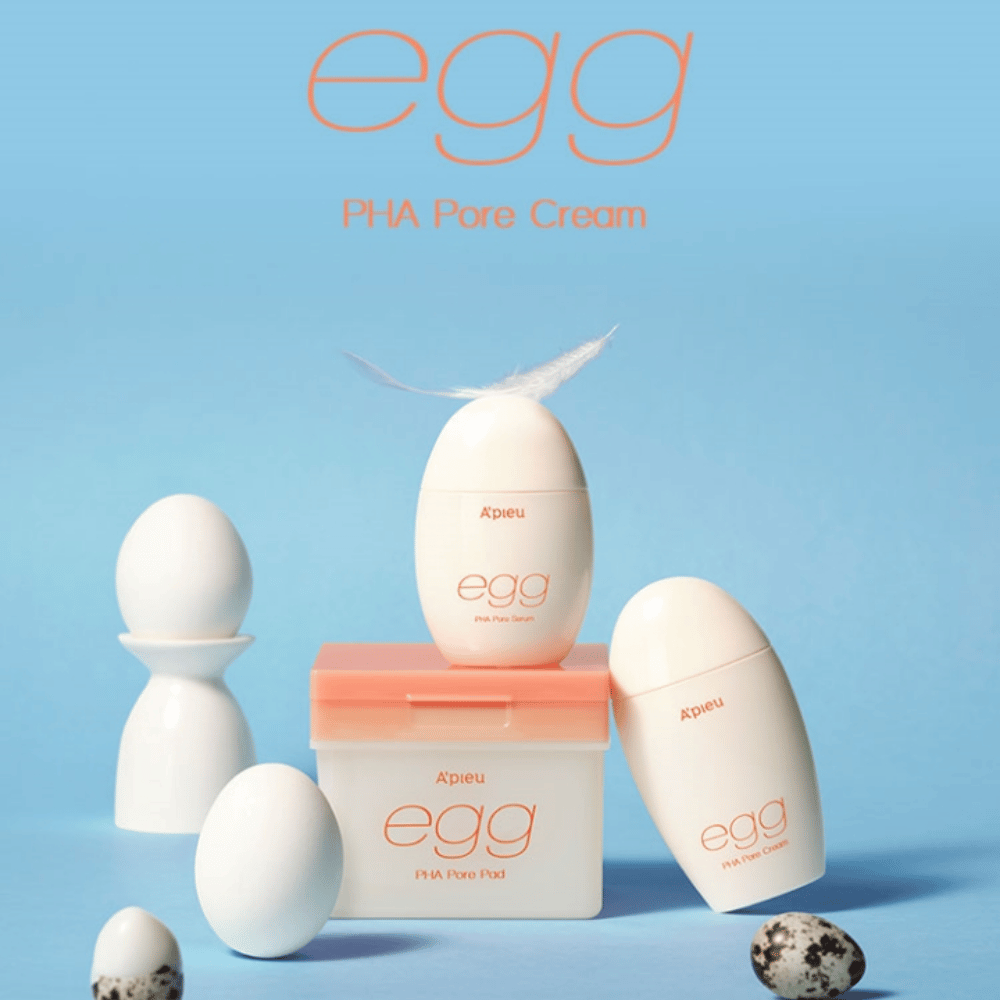 A'pieu Egg PHA Pore-serie – eggformede produkter som serum, krem og pads, stilfullt arrangert på blå bakgrunn med egg og fjær som symboliserer skånsom hudpleie.