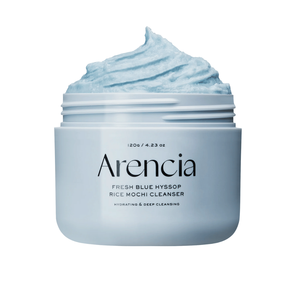 Nærbilde av en åpen krukke Arencia Fresh Blue Hyssop Rice Mochi Cleanser. Den blå rengjøringskremen har en luftig, pisket tekstur og fyller toppen av krukken.