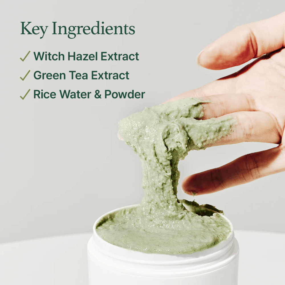 En hånd løfter opp Arencia Fresh Green Rice Mochi Cleanser fra en krukke. Den grønne, tyktflytende kremen strekkes mellom fingrene. Teksten lister opp ingredienser: Witch Hazel, Green Tea, Rice Water & Powder.