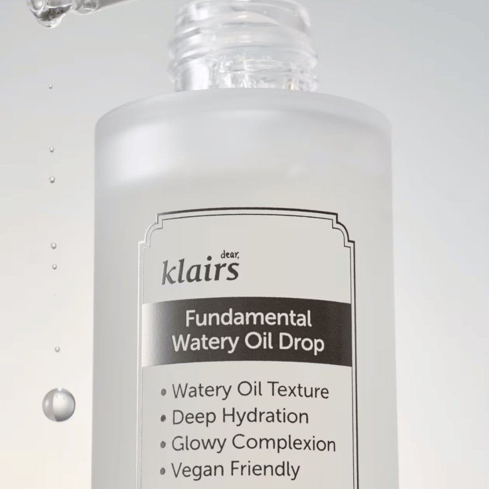 Nærbilde av flasken Klairs Fundamental Watery Oil Drop, med tekst som fremhever produktets egenskaper som "Watery Oil Texture", "Deep Hydration", "Glowy Complexion" og "Vegan Friendly".