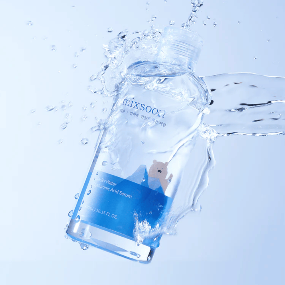 Mixsoon Glacier Water Hyaluronic Acid Serum-flaske med blå etikett og isbjørnsmotiv omgitt av sprutende vann mot lyseblå bakgrunn.