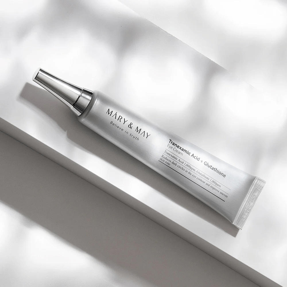Nærbilde av Mary&May Tranexamic Acid + Glutathione Eye Cream med metallapplikator, utviklet for å lysne mørke ringer og jevne ut hudtonen rundt øynene.