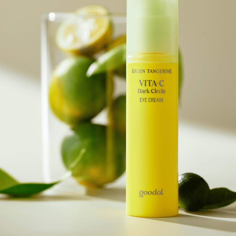 En flaske Goodal Green Tangerine Vita C Dark Circle Eye Cream 30ml på et bord ved siden av en lime.