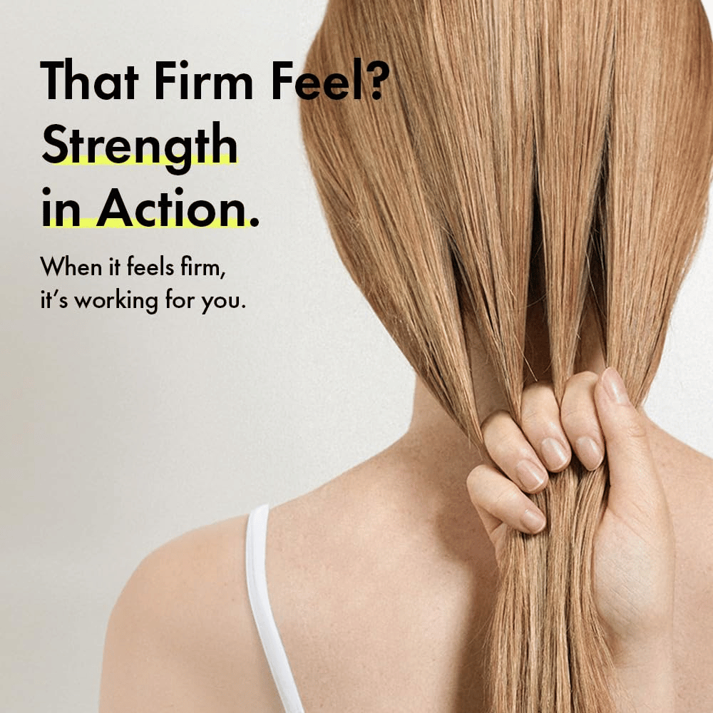 Person holder i håret sitt for å illustrere sterkere hårstrå og en fastere hårfølelse etter bruk av Grabity g0.0 Hair Lifting Shampoo Strong.