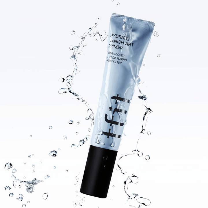 TFIT Hydrate Vanish Art Primer i blå tub omges av stänkande vatten, vilket symboliserar produktens återfuktande egenskaper och fräscha känsla vid applicering.
