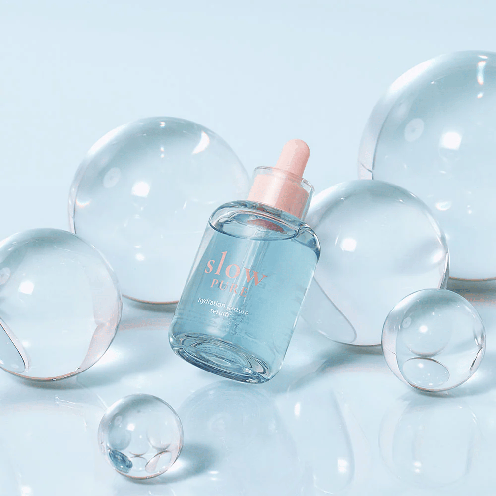 Slow Pure Hydration Texture Serum plassert blant gjennomsiktige bobler, symbol for intens fuktighet.