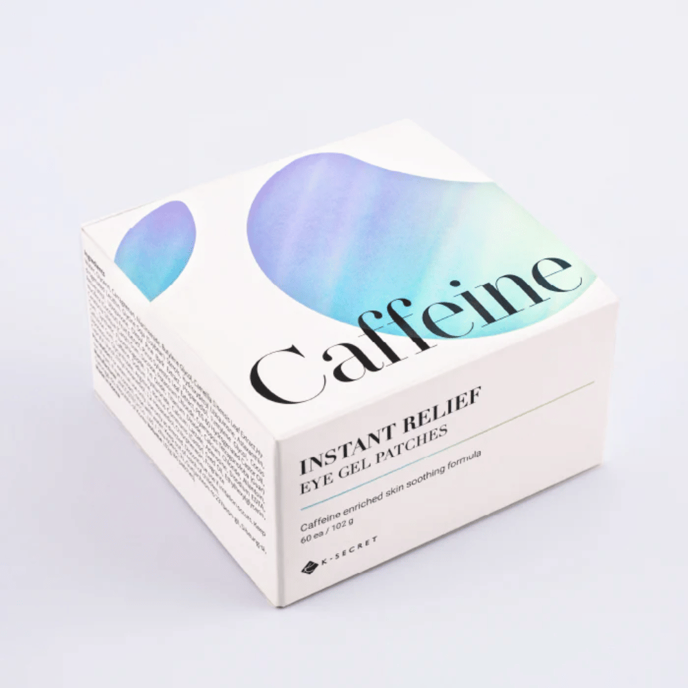 Pakke av K-Secret Instant Relief Eye Gel Patches med koffein i hvit design med blå og grønne toner.
