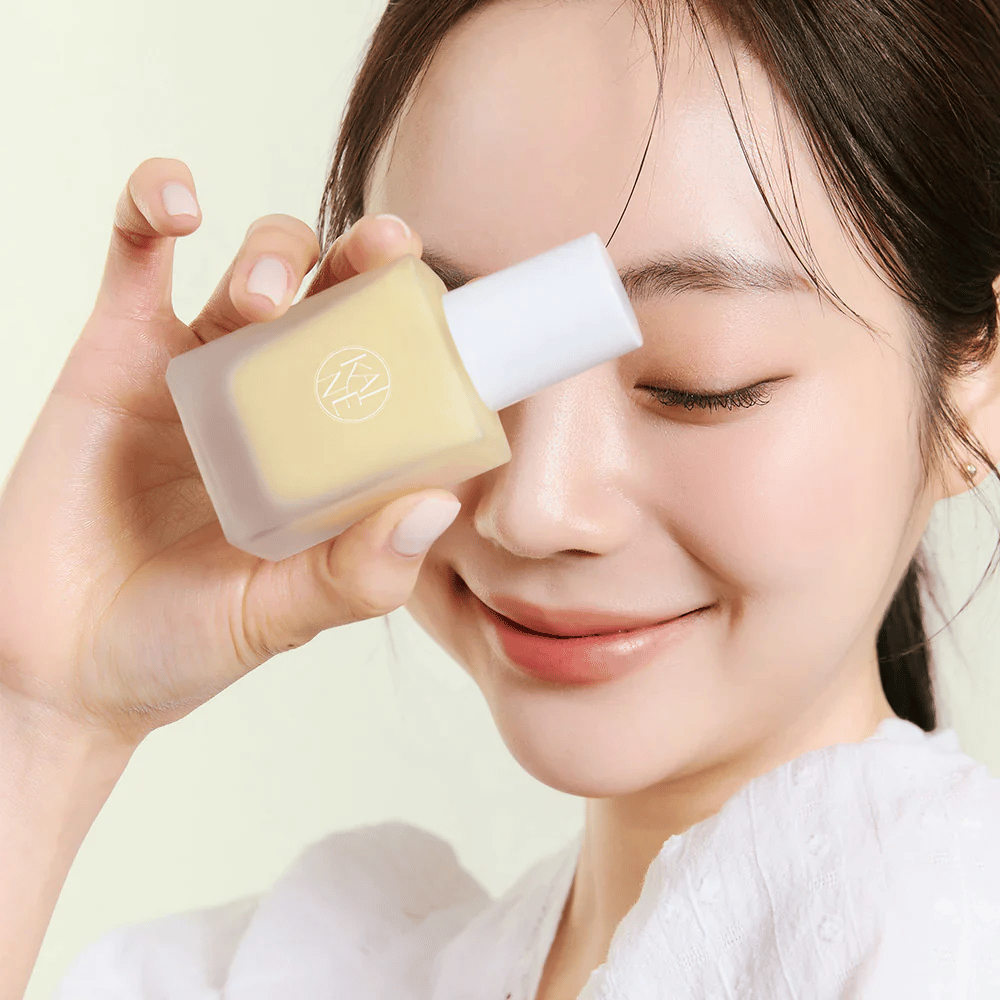 En kvinne holder i en flaske KAINE Vita Drop Serum 30ml.