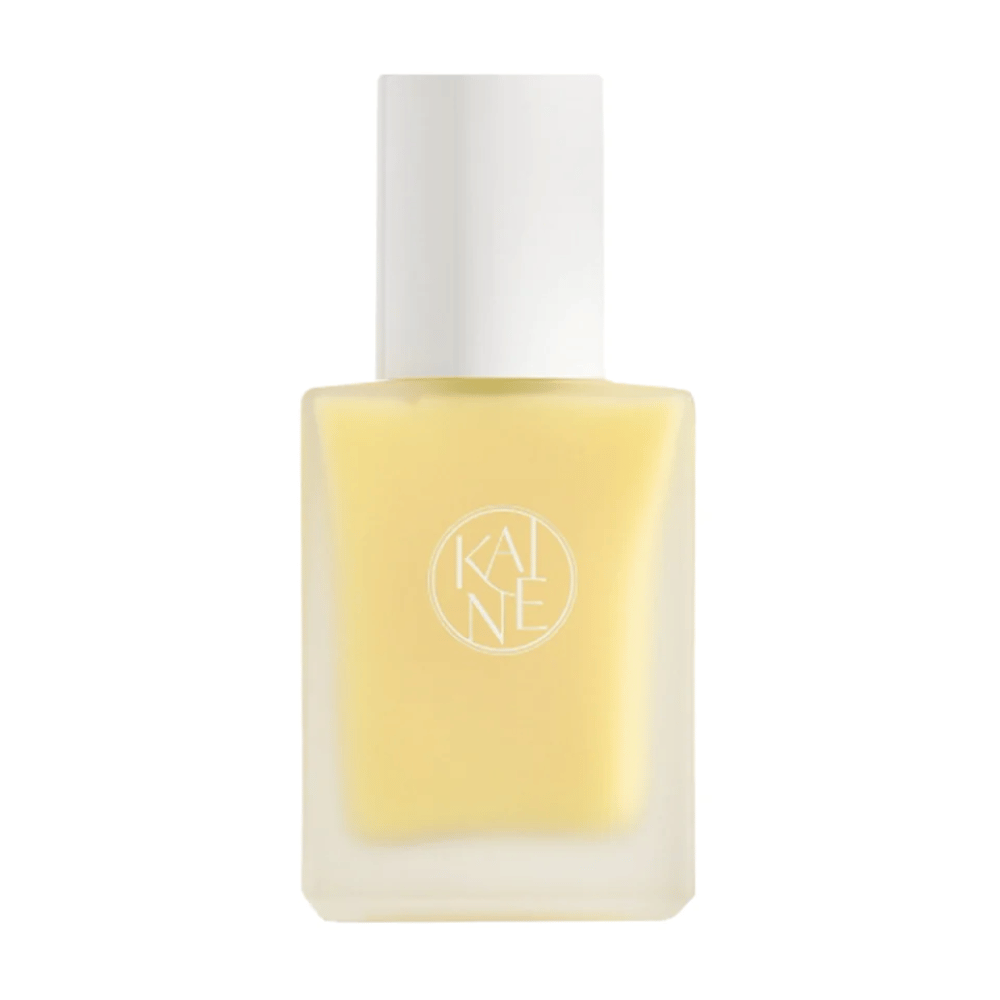 En gul Vita Drop Serum 30ml flaske på hvit bakgrunn med KAINE hudpleieprodukter.