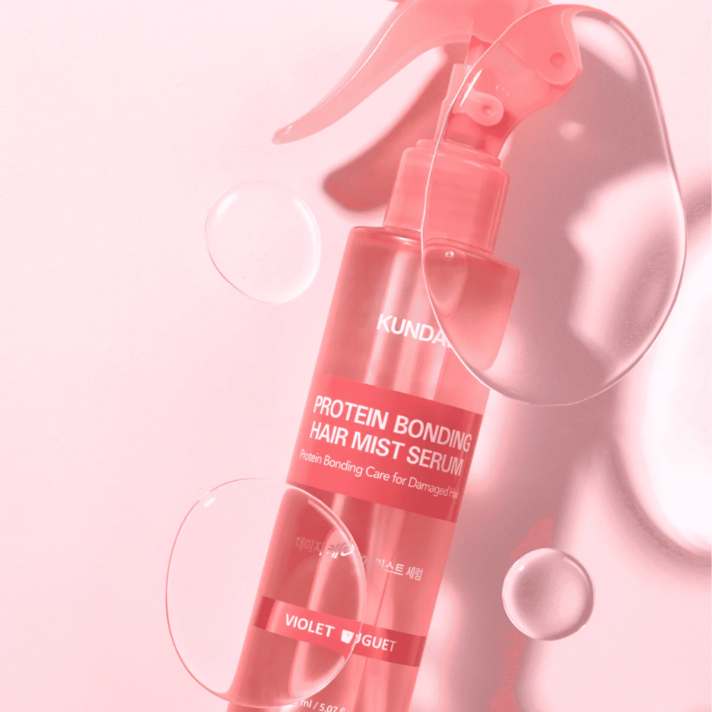 KUNDAL Protein Bonding Hair Mist Serum Violet Bouquet i rosa sprayflaske, fotografert mot rosa bakgrunn med vanndråper.