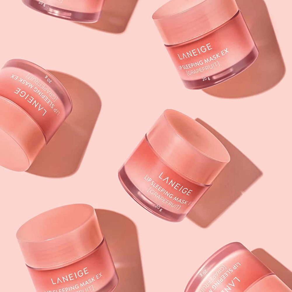 Fire bokser LANEIGE Lip Sleeping Mask Grapefrukt 20g på rosa bakgrunn, fremmer grapefrukt og fuktighet.