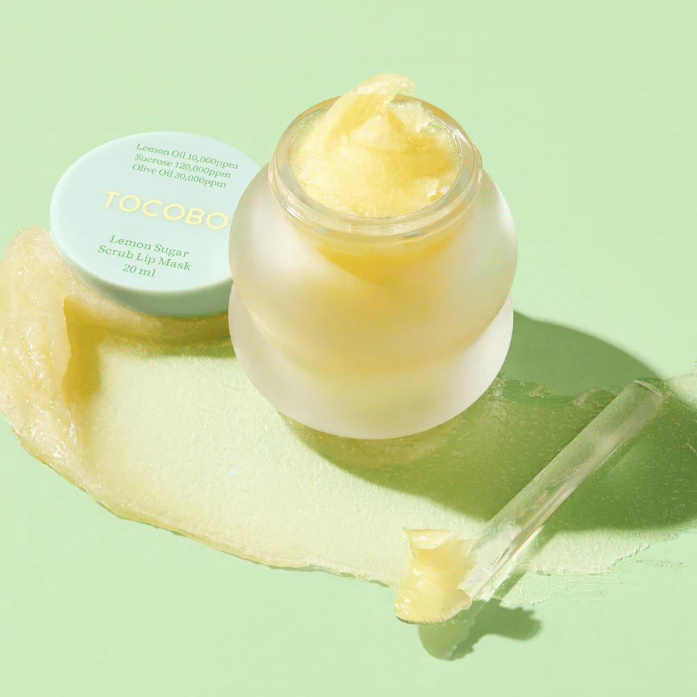 Åpen krukke med Tocobo Lemon Sugar Scrub Lip Mask på en grønn bakgrunn, med innholdet tydelig synlig.