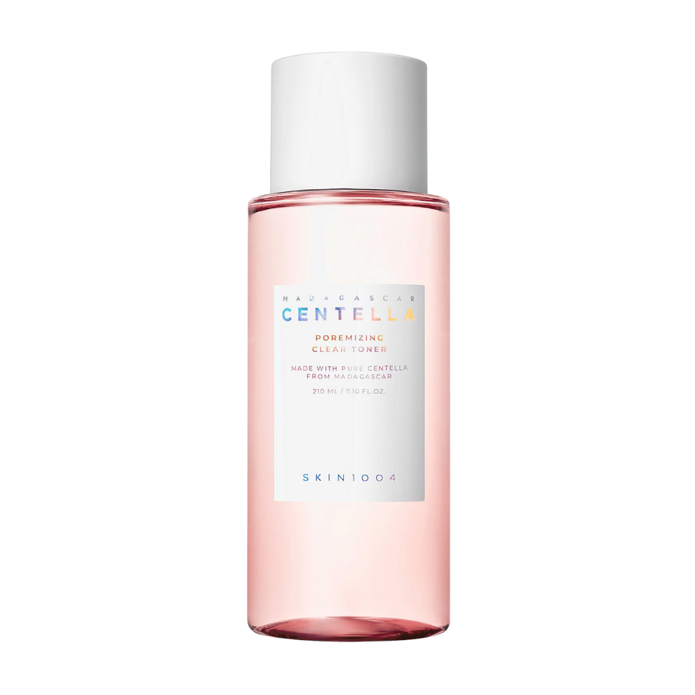 En flaske med Madagascar Centella Poremizing Clear Toner, som er transparent med en rosa tone. Produktet har en hvit kork og etikett med teksten "Poremizing Clear Toner" og "Made with Pure Centella from Madagascar." Flasken rommer 210 ml og gir en følelse av friskhet og hudpleie.