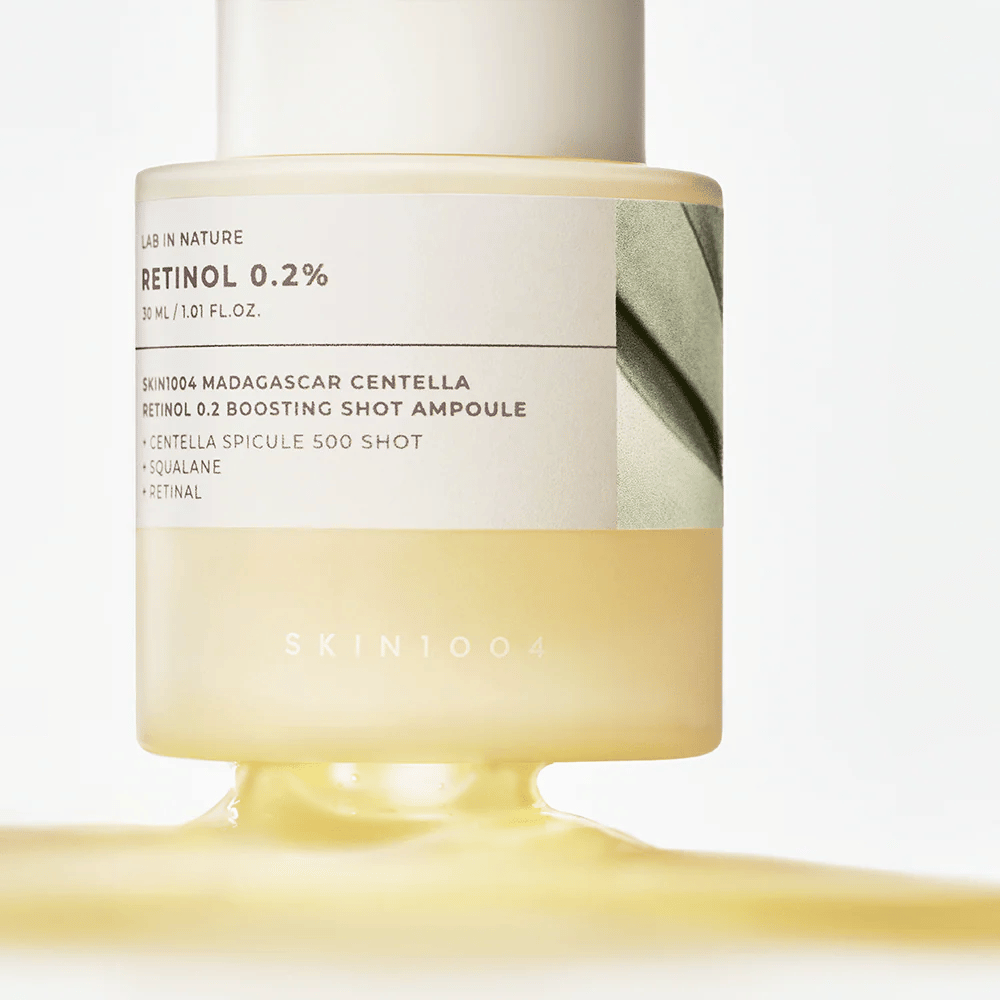 Nærbilde av SKIN1004 Madagascar Centella Retinol 0.2 Boosting Shot Ampoule som viser den lett gule, silkemyke konsistensen av retinolserumet for nattlig hudfornyelse.