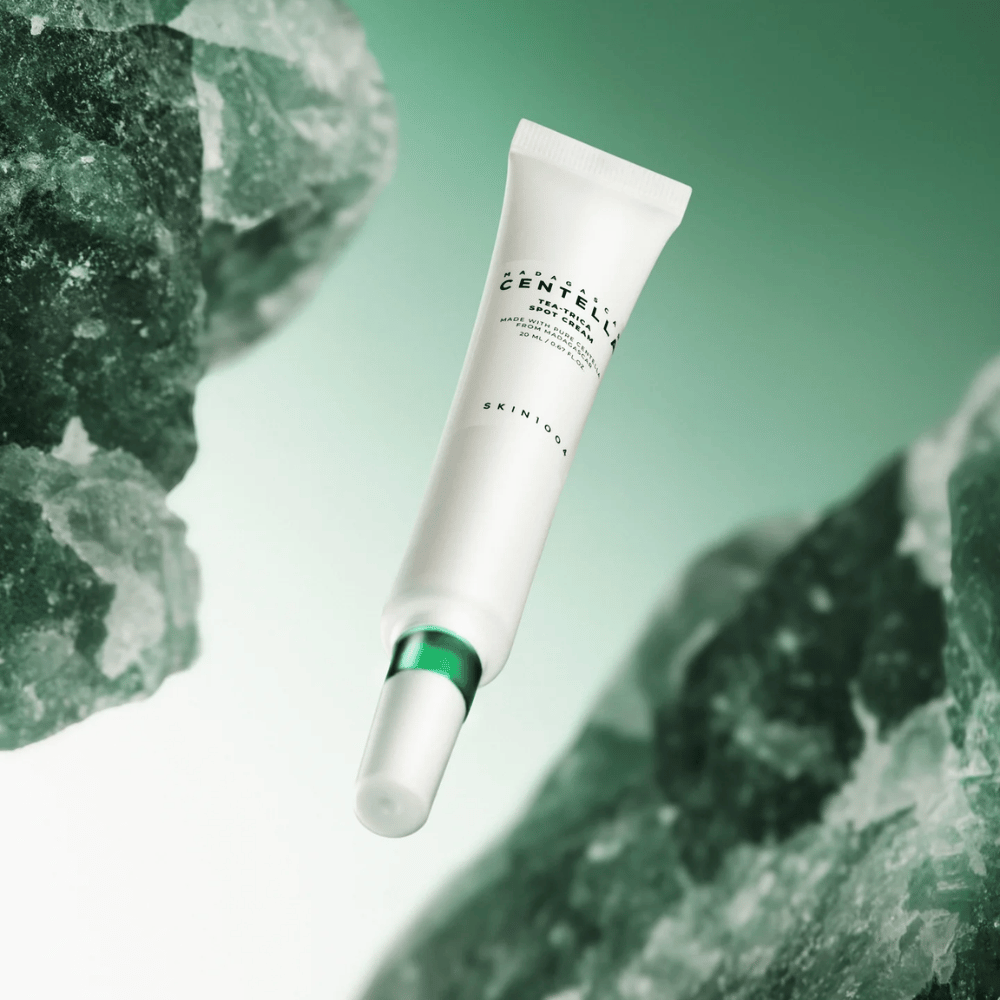 SKIN1004 Madagascar Centella Tea-Trica Spot Cream 20 ml mot akne og kviser, produktbilde med grønn bakgrunn og krystallstruktur – beroligende spot treatment med centella asiatica og tea tree.