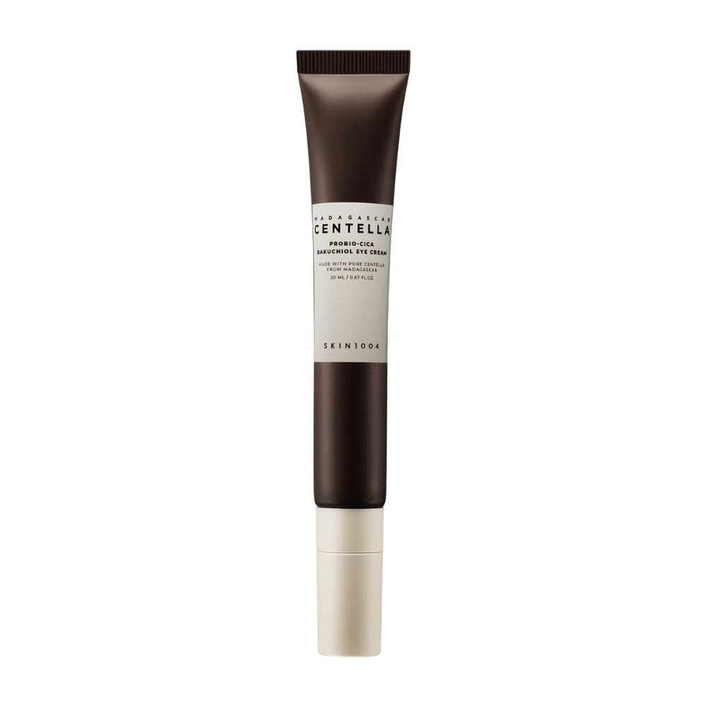 En tube av "Madagascar Centella Probio-Cica Bakuchiol Eye Cream" fra SKIN1004. Produktet er designet for øyeområdet og inneholder ingredienser som centella fra Madagaskar og bakuchiol, kjent for sine hudpleiende og fuktighetsgivende egenskaper. Tuben er stilren med en mørkebrun farge som går over til hvitt.