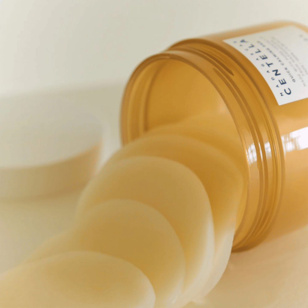 Åpnet boks med SKIN1004 Madagascar Centella Quick Calming Pad – flere runde toner pads i lysegul væske er synlige, boksen er ravfarget med hvit etikett.