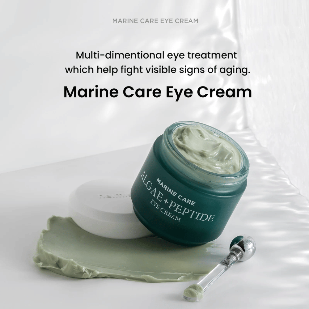 Heimish Marine Care Algae + Peptide Eye Cream i en åpen boks med grønnaktig krem. Kremen er spredt ved siden av boksen og en applikator ligger ved siden av. Produktet bekjemper aldringstegn og gir intens fuktighet.