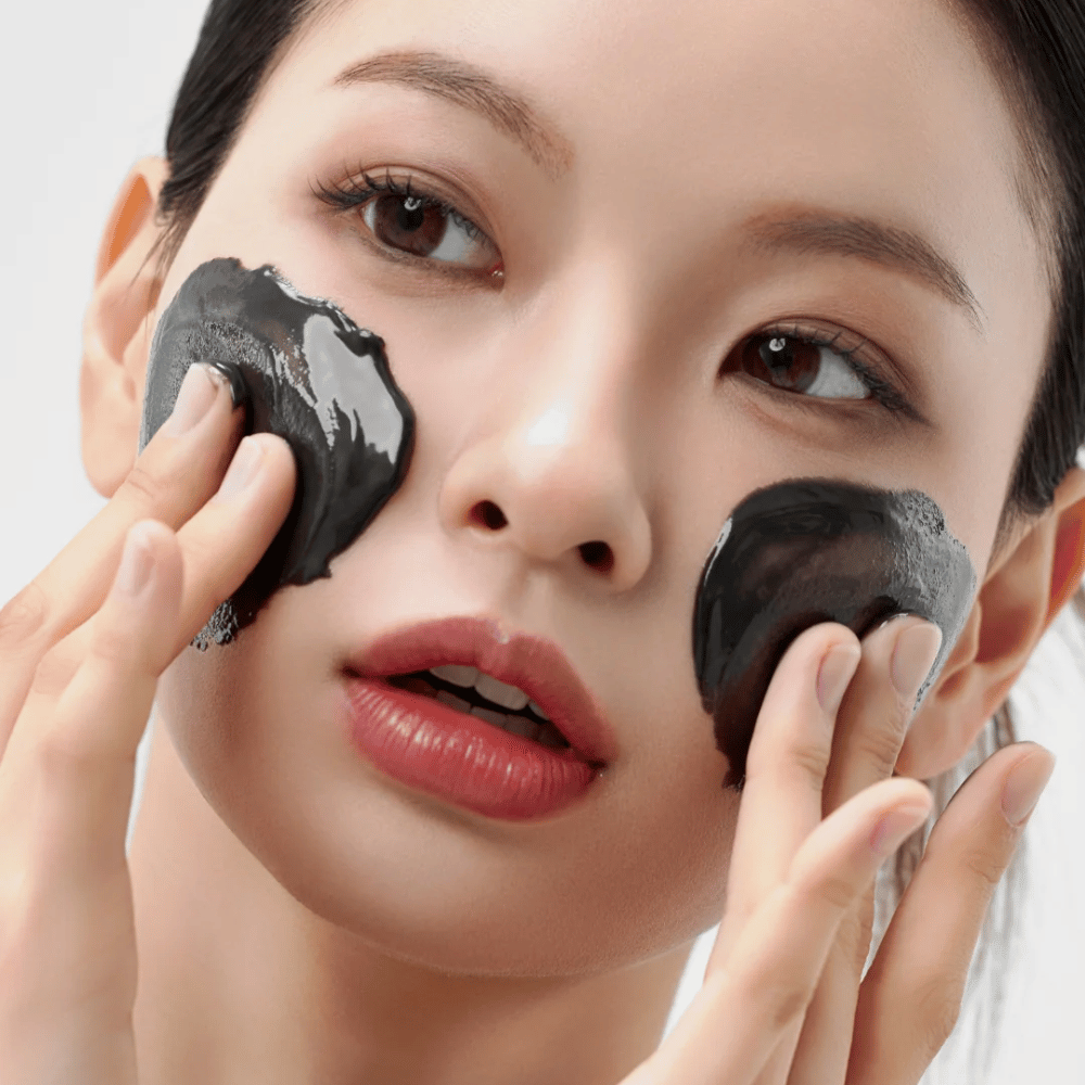Nærbilde av påføring av Hvordan Midnight Soothing Cleansing Balm i ansiktet. Myk rensebalm som løser opp urenheter og gir en rolig hudfølelse.