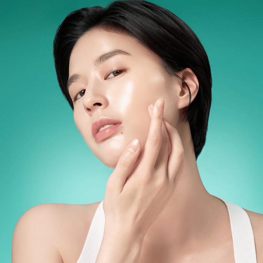 Kvinne med strålende hud etter å ha brukt Purito Mighty Bamboo Panthenol Serum – beroligende og fuktighetsgivende serum som styrker hudbarrieren.