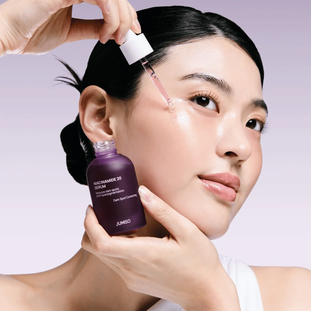 Kvinne påfører Jumiso Niacinamide 20 Serum – glødgivende koreansk serum som jevner ut hudtonen og reduserer pigmentflekker.