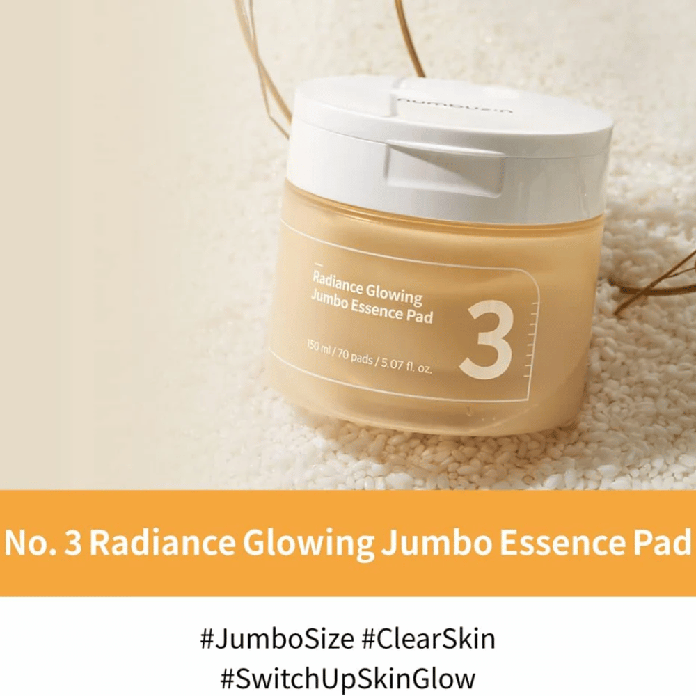 Boks med numbuzin No. 3 Radiance Glowing Jumbo Essence Pad plassert på ris, teksten på bildet fremhever jumbo-størrelse og hudens glød.
