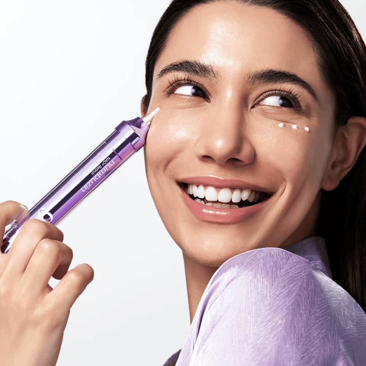 Modell som påfører No.9 NAD+ Retinol Volumetox Eye Cream rundt øynene med presisjonsapplikator, for målrettet pleie mot mørke ringer og fine linjer.
