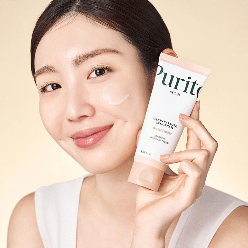 Kvinne påfører Purito Oat-In Calming Gel Cream i ansiktet. Mild og fuktighetsgivende gelkrem for sensitiv og irritert hud.