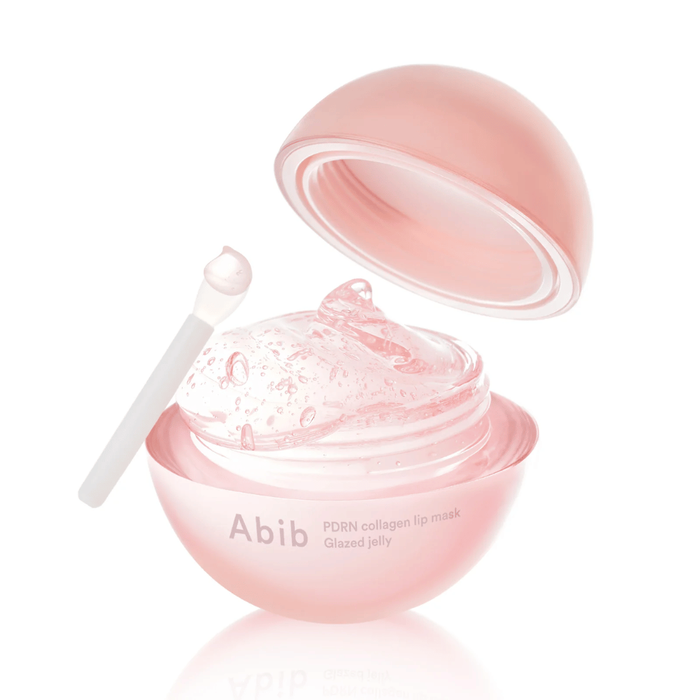 Rosa rund boks med Abib PDRN Collagen Lip Mask Glazed Jelly, åpen med lokk lent bakover. Gjennomsiktig gel med luftbobler vises i boksen sammen med en liten spatel.