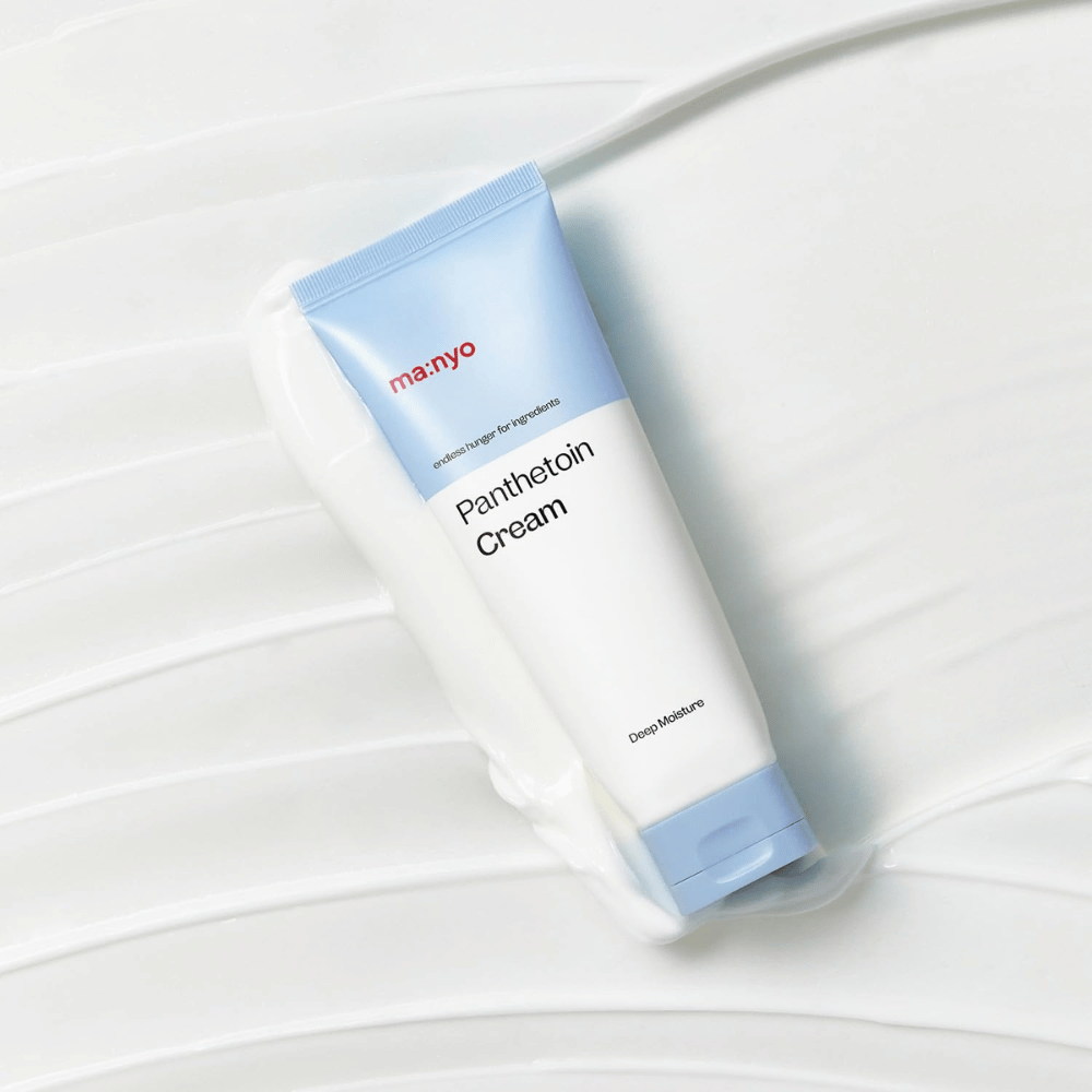 2. Ma:nyo Panthetoin Cream – fuktighetsgivende ansiktskrem i hvit og lyseblå tube omgitt av kremet tekstur på hvit bakgrunn