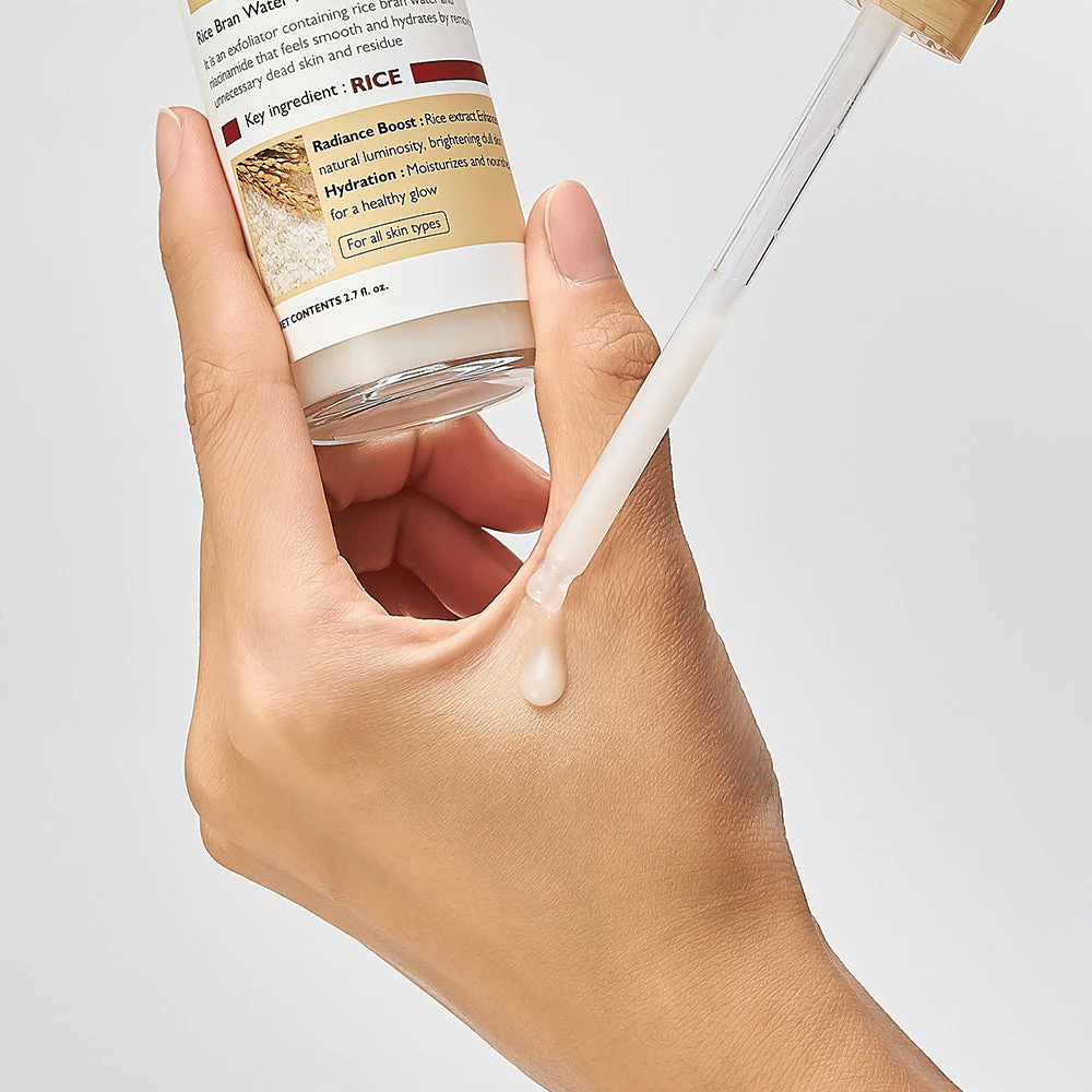 Nærbilde av Dr.Melaxin Peel Shot Rice Ampoule påført med pipette på hånd, lettflytende eksfolierende ampull som absorberes raskt og gir fuktet, glatt hud.