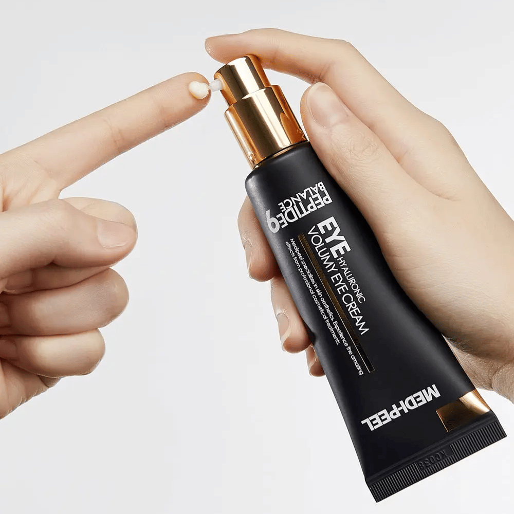 Påføring av MEDI-PEEL Peptide 9 Hyaluronic Volumy Eye Cream på fingertupp – fuktighetsgivende øyekrem med peptidkompleks som hjelper til med å redusere fine linjer og gi plumpet hud.