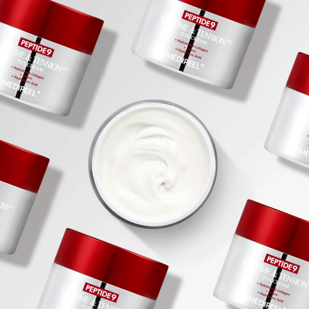 Flere bokser av MEDI-PEEL Peptide 9 Volume & Tension Tox Cream arrangert mot hvit bakgrunn. Produktet fukter intensivt og gir huden volum og glød.