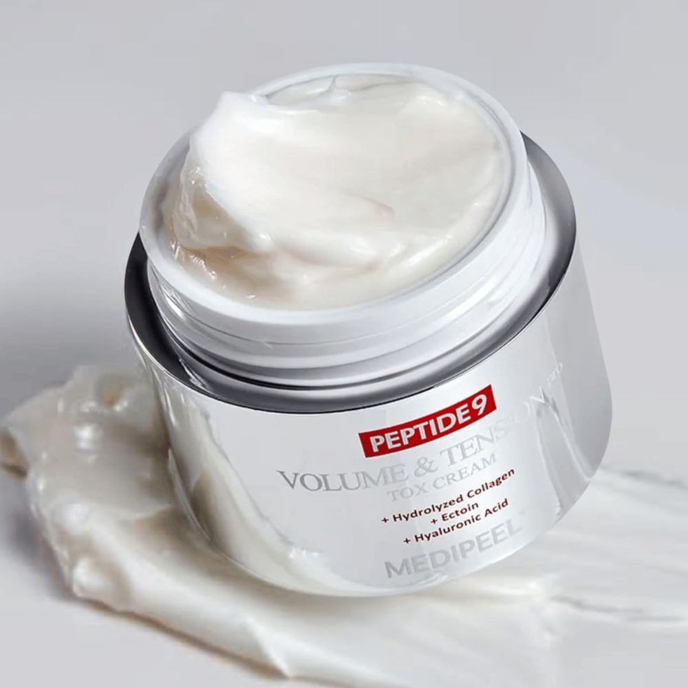 Nærbilde av MEDI-PEEL Peptide 9 Volume & Tension Tox Cream. Den rike kremen inneholder hydrolysert kollagen, ectoin og hyaluronsyre for fastere og fuktet hud.