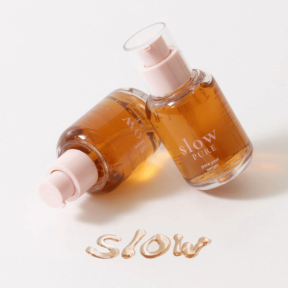 To flasker Slow Pure Pore Peel Serum med pumpe, tekst skrevet i serum på overflaten: "Slow".