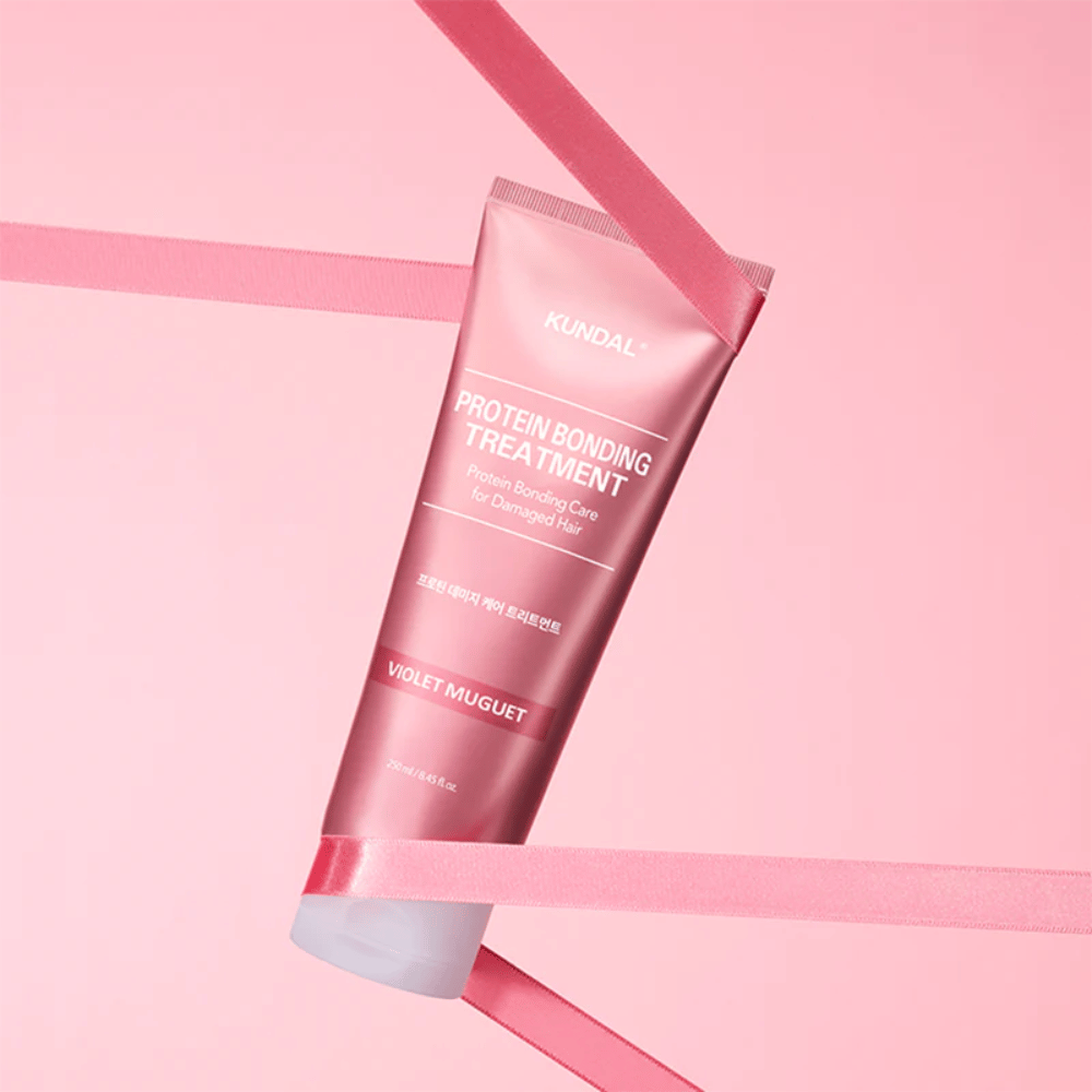 KUNDAL Protein Bonding Treatment Violet Muguet i rosa tube 250 ml mot rosa bakgrunn med dekorative bånd.