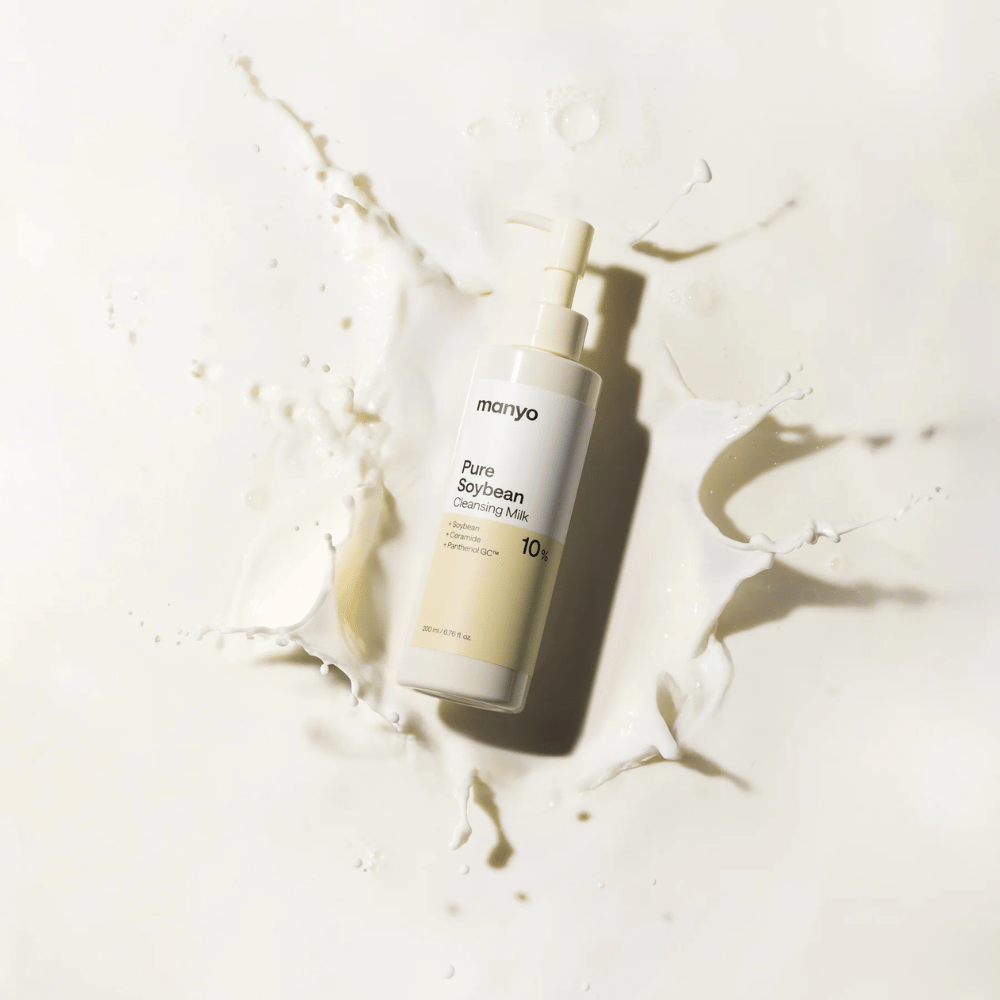 1. Ma:nyo Pure Soybean Cleansing Milk – mild rensemelk med soya i pumpeflaske omgitt av melkesprut på lys bakgrunn