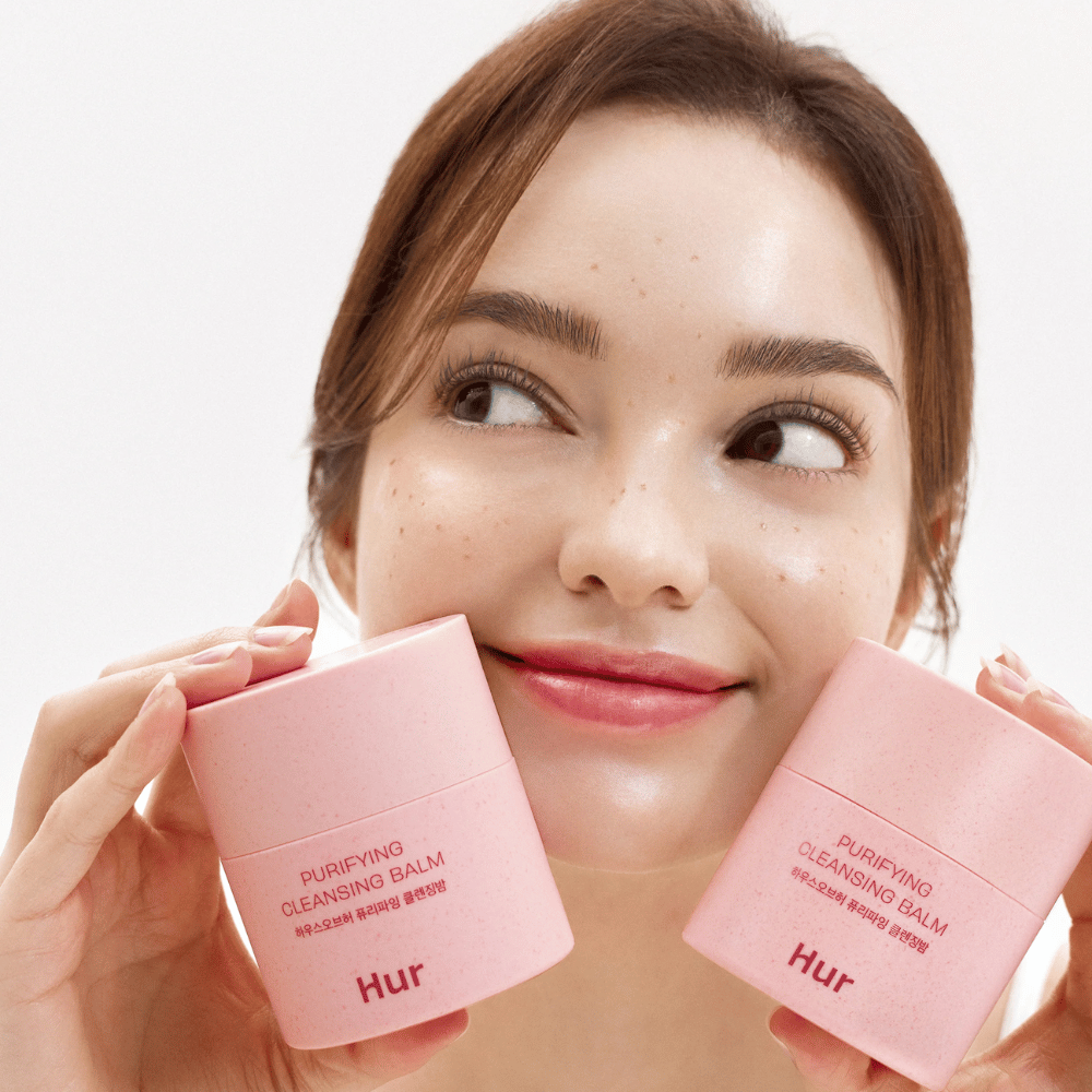 Modell holder to krukker Hvordan Purifying Cleansing Balm. Mild rensebalm som passer sensitiv hud og gir en frisk, fuktet følelse etter rensing.