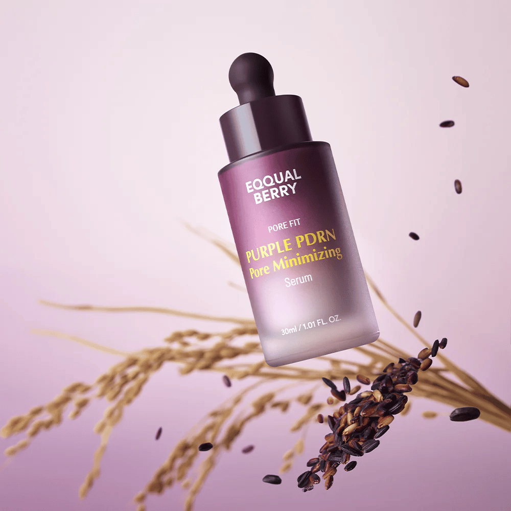 Flaske med Equal Berry Purple PDRN Pore Minimizing Serum svever mot lilla bakgrunn, omgitt av svarte riskorn og risstrå.