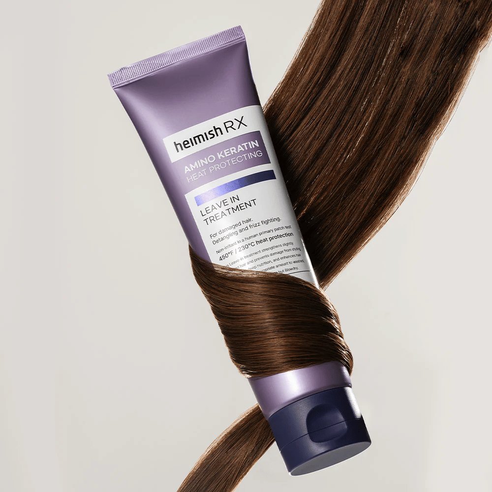 Heimish RX Amino Keratin Leave-In Treatment – næringsrik varmebeskyttende hårbehandling omgitt av glansfullt hår, symboliserer styrkende og fuktighetsgivende effekt for skadet hår.