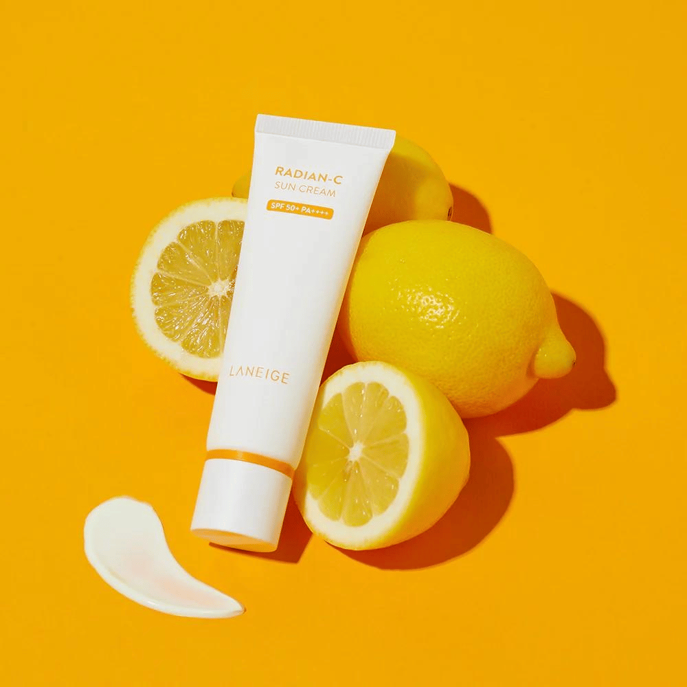 LANEIGE Radian-C Sun Cream SPF 50+ PA++++ med sitroner og en klatt solkrem på en fargerik gul bakgrunn.