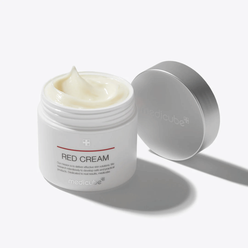 Åpen boks med medicube Red Cream 50ml – en lysegul ansiktskrem i hvit pakning med sølvfarget lokk, utviklet for akneutsatt hud.