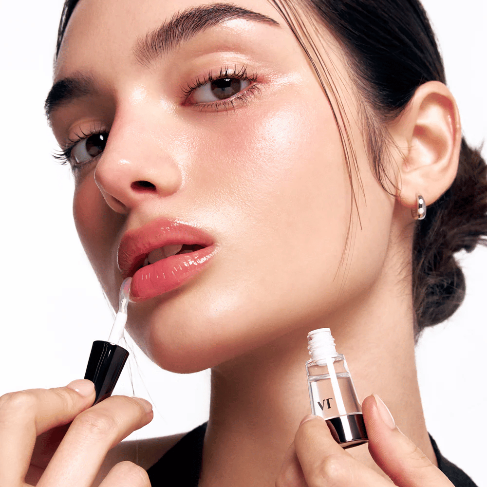 Modell påfører VT Cosmetics Reedle Shot Lip Plumper Beginner på leppene for naturlig plumping, glans og fuktighet med lett prikkende effekt.