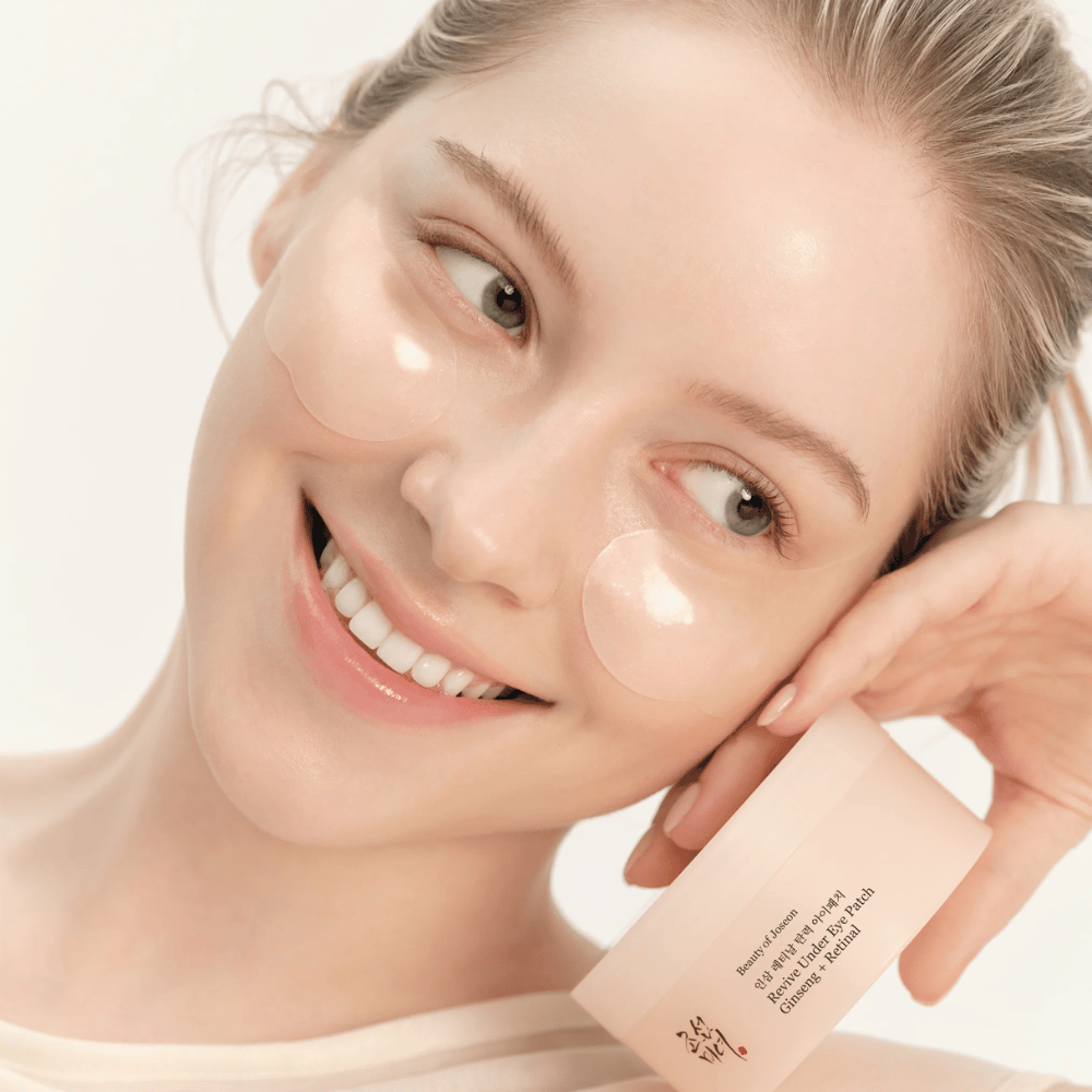 Modell med Beauty of Joseon under eye patches og produkt i hånden, øyenlapper med ginseng og retinal for et mer våkent og glattere øyeområde.