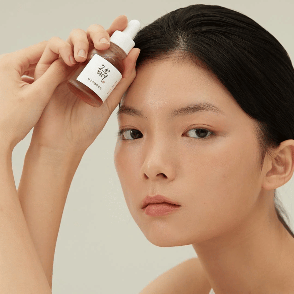Modell holder Beauty of Joseon Revive Serum ved kinnet – næringsrikt serum med ginseng og snegleslim.