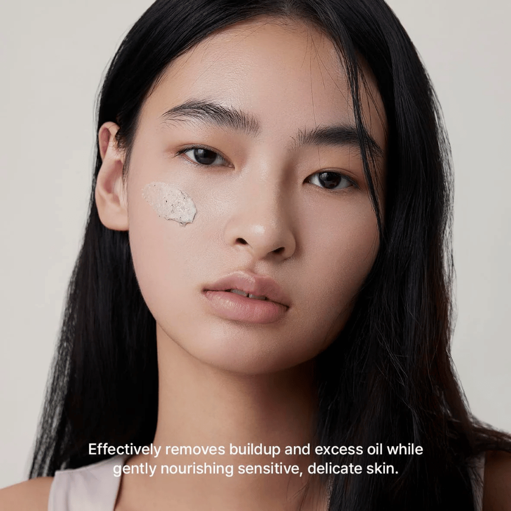 Modell med Arencia Rice + LHA Pore Control Rice Cake Cleanser påført på kinnet, mild ansiktsrens som effektivt fjerner smuss og overflødig sebum uten å tørke ut huden.