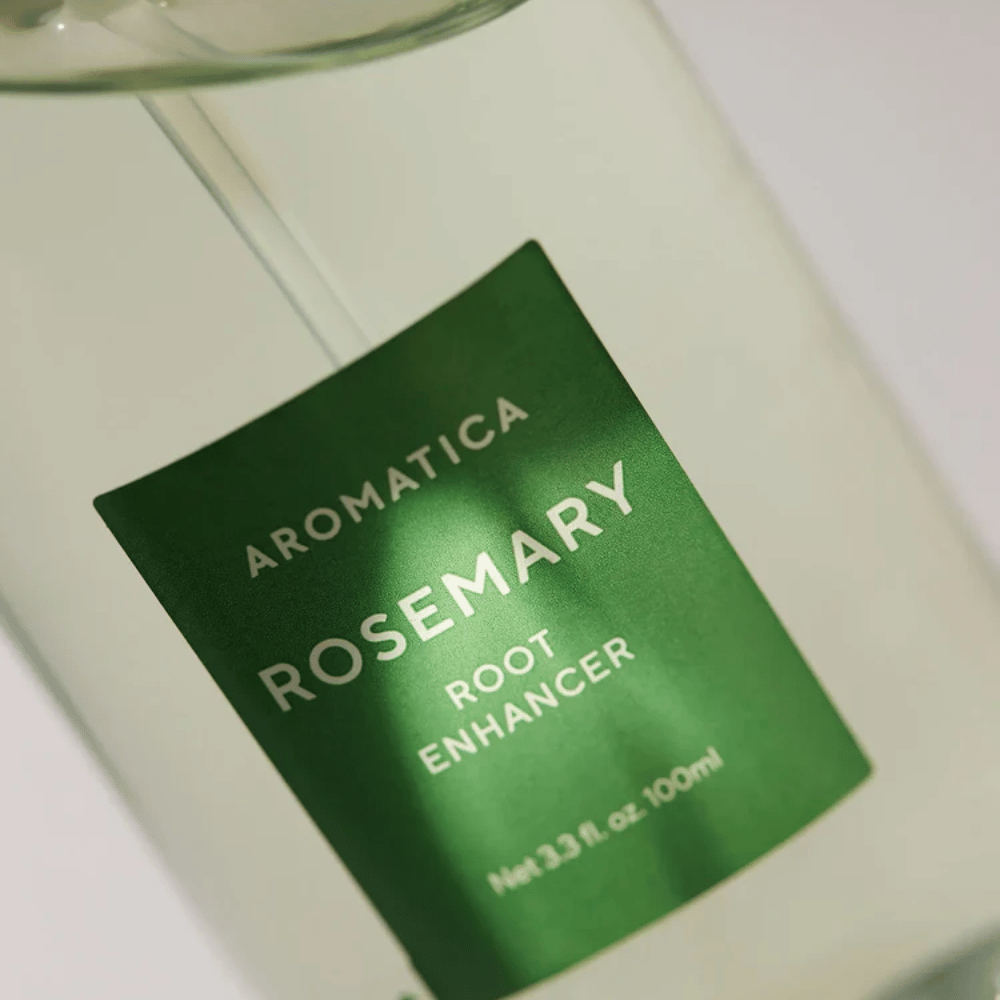 Detaljbilde av etiketten på AROMATICA Rosemary Root Enhancer. Den grønne etiketten og den transparente flasken fremhever produktets rene og minimalistiske utseende.