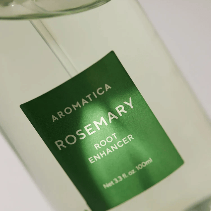 Detaljbilde av etiketten på AROMATICA Rosemary Root Enhancer. Den grønne etiketten og den transparente flasken fremhever produktets rene og minimalistiske utseende.