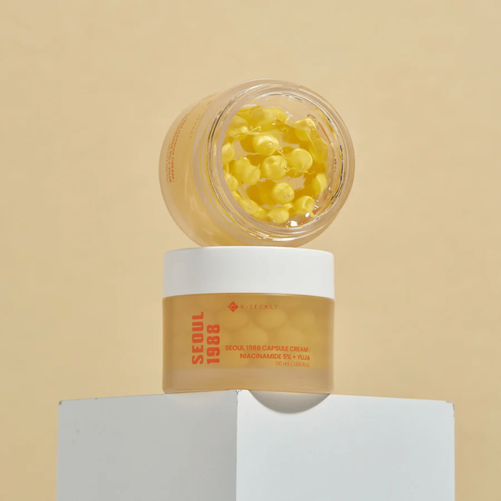 Stilren oppstilling: To bokser med Seoul 1988 Capsule Cream, en åpen og en lukket, plassert mot beige bakgrunn.